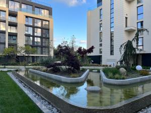 a pond in front of two tall buildings at Luxe Sea in Saints Constantine and Helena