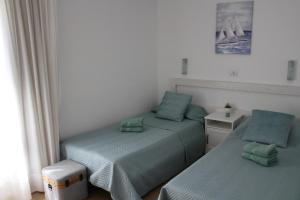 a bedroom with two beds and a table and a window at Canaima 307 in Puerto Rico de Gran Canaria +44 photos