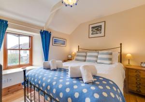 a bedroom with a large bed with blue and white pillows at Crown Mine Cottage in St. Just
