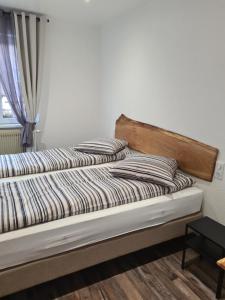 Bett mit gestreiften Kissen auf einem Zimmer in der Unterkunft Gîte Au Coin du Chêne in Lembach
