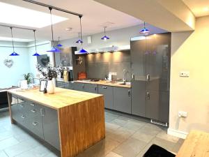 a large kitchen with gray cabinets and blue lights at The Old Bakery in Cheltenham