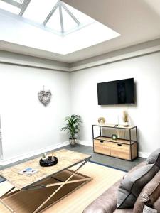 a living room with a couch and a flat screen tv at The Old Bakery in Cheltenham