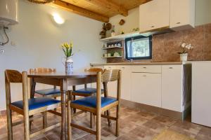 eine Küche mit einem Holztisch und Stühlen in der Unterkunft Holiday home Mola in Ugljan