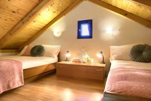 ein Schlafzimmer im Dachgeschoss mit zwei Betten und einem Fenster in der Unterkunft Holiday home Mola in Ugljan