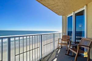 a balcony with two chairs and a view of the beach at Oceania Beach Club Superior Beachfront Condos in New Smyrna Beach