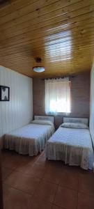 1 dormitorio con 2 camas y techo de madera en Vivienda Turística Rural, en Granada