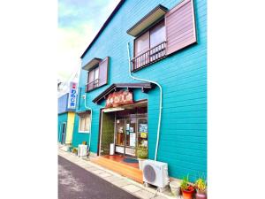ein blaues Gebäude an der Straßenseite in der Unterkunft Ryokan Warajisha - Vacation STAY 62566v in Goto