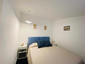 a small white bedroom with a bed and a nightstand at VILLA GAZZANO in Siracusa