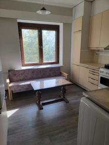a kitchen with a bench in front of a window at Sunny apartment next to a beautiful lake in the forest in Imatra