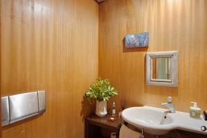 La salle de bains est pourvue d'un lavabo et d'un vase de fleurs. dans l'établissement Villa do Bosque, à Guilhabreu