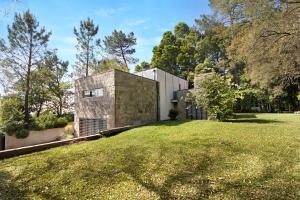 une maison dans un champ avec une pelouse dans l'établissement Villa do Bosque, à Guilhabreu
