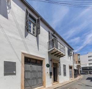 un edificio bianco con porta e balcone di Edem Traditional House a Larnaka