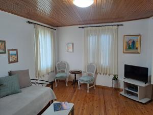 a living room with a couch and a tv at Mary's Art House in the center of Old town in Corfu