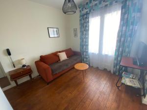 a living room with a couch and a window at Oscar Hôtel Le Havre Centre in Le Havre