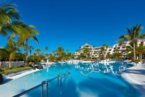 a swimming pool at a resort with palm trees and condos at Parque Santiago III Official in Playa de las Americas