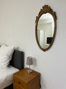 a mirror on a wall next to a bed and a table at privates Doppelzimmer mit separatem Eingang in Utting am Ammersee