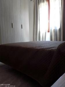 un letto in una stanza con finestra di Appartamento B di Vico Martiri a Teulada