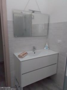 bagno bianco con lavandino e specchio di Appartamento B di Vico Martiri a Teulada