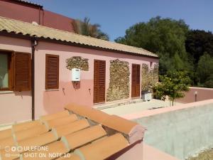 una villa con piscina e una casa rosa di Appartamento B di Vico Martiri a Teulada