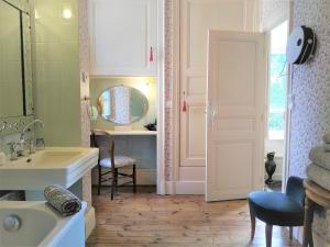 uma casa de banho com um lavatório e um espelho em Château de la Vernède em Saint-Rémy-de-Chargnat