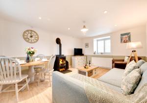 a living room with a couch and a table at Flora Belle Cottage in Sennen