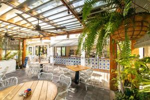 a restaurant with tables and chairs and plants at Parque Santiago III Official in Playa de las Americas