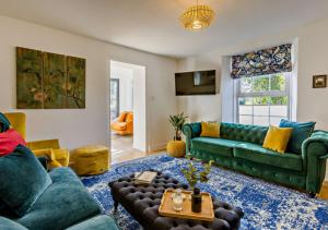 un soggiorno con divano verde e tavolo di Helebridge House a Marhamchurch