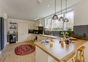 a kitchen with a large wooden island in the middle at Helebridge House in Marhamchurch