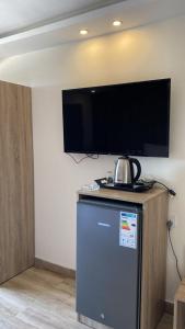 TV en la pared con nevera en la habitación en Castle beach hotel en Áqaba