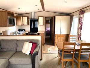 a living room and kitchen with a couch and a table at Cabin 38 in Aviemore
