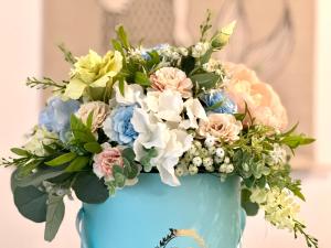 a blue vase filled with flowers on top of a cake at Apartament VITAMIN SEA in Jantar