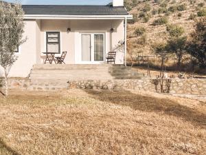 una casa con dos sillas sentadas en el porche delantero en Little Karoo, en Somerset East