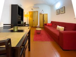 a living room with a red couch and a red rug at Acolhedor espaço no centro da cidade in Évora