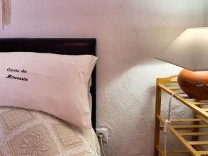 a bed with a white pillow next to a wall at Évora City Break Apartment with Patio in the Historic Centre in Évora