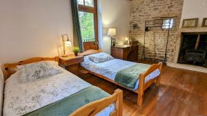 een slaapkamer met 2 bedden en een open haard bij Au fil du temps in Santenay