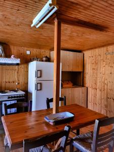 kuchnia z drewnianym stołem i białą lodówką w obiekcie Παραδοσιακό σπίτι με θέα w mieście Tríkeri