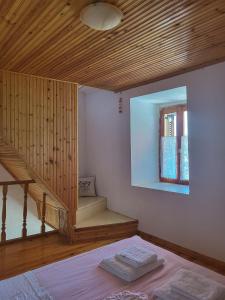 sypialnia z łóżkiem i drewnianym sufitem w obiekcie Παραδοσιακό σπίτι με θέα w mieście Tríkeri