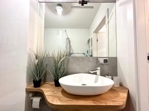 a bathroom with a white sink on a wooden counter at Apartament VITAMIN SEA in Jantar