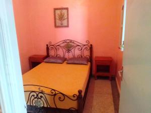 a bedroom with a black bed with orange walls at aglou plage in Tiznit