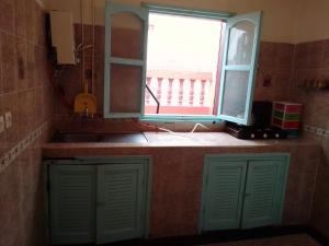 a bathroom with two green doors and a window at aglou plage in Tiznit