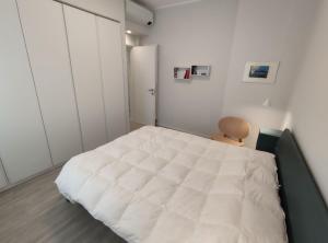 a bedroom with a large white bed and a refrigerator at Casa Charlotte in Rapallo