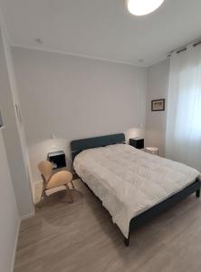 a bedroom with a large bed and a chair at Casa Charlotte in Rapallo