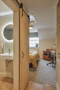 a bathroom with a door leading to a bedroom at Full Moon Inn Rudge in Frome