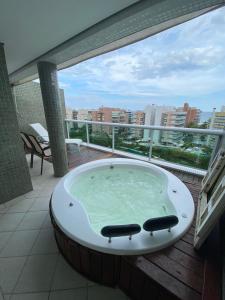 a bath tub on a balcony with a view of a city at Cobertura Ilha da Madeira in Riviera de São Lourenço