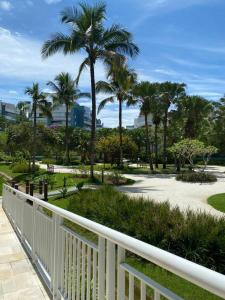 a white fence in a park with palm trees at Cobertura Ilha da Madeira in Riviera de São Lourenço