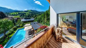 a house with a swimming pool on a wooden deck at Luxusapartment Müllerhaus in Mühlbach am Hochkönig