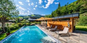 basen z krzesłami i domkiem w obiekcie Luxusapartment Müllerhaus w mieście Mühlbach am Hochkönig