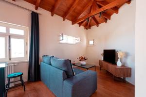 a living room with a blue couch and a tv at Homie Suites - Turna Residences in Cihangir in Istanbul