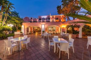 a patio with tables and chairs in front of a building at Hotel San Valentino Terme in Ischia