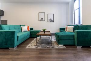 a living room with green couches and a table at Water Street by Ustay Aparthotels in Liverpool